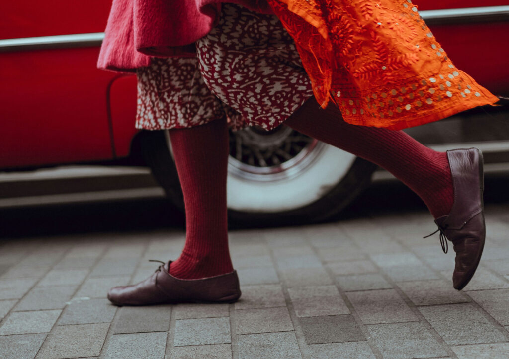 Person walking in front of a red vehicle