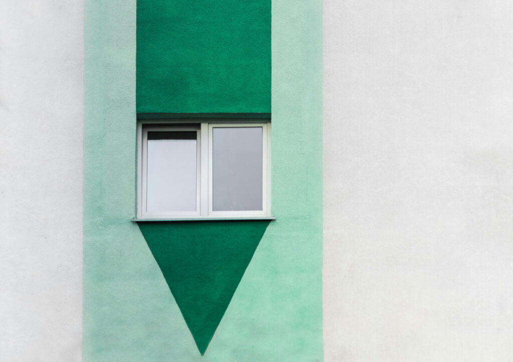 White wooden sliding glass window in green and white building