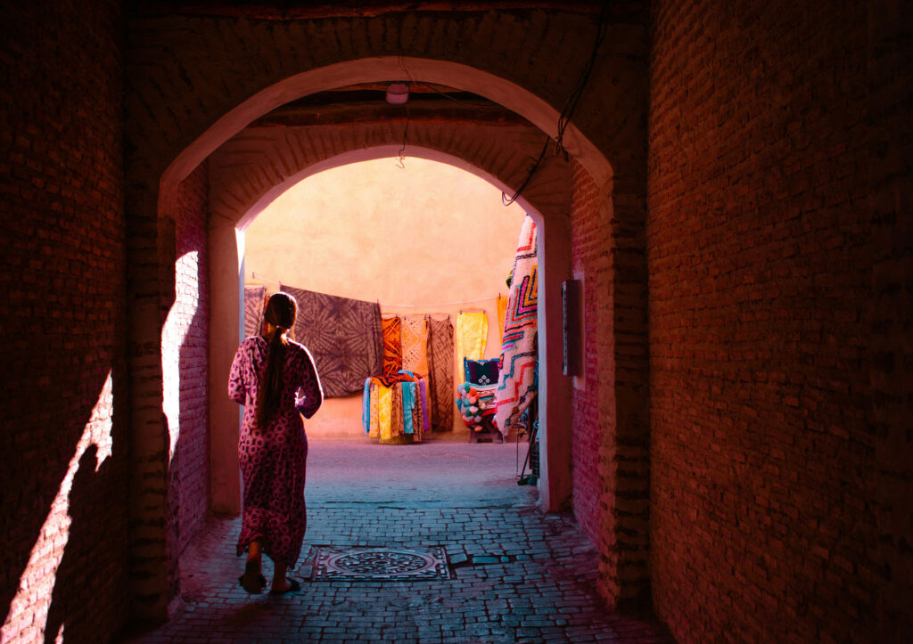 A person walks through an arched passage