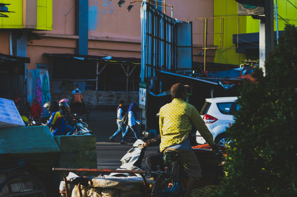 A man riding a bike down a street close to a street sign