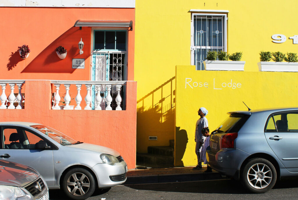 Two cars parked in front of a colourful building