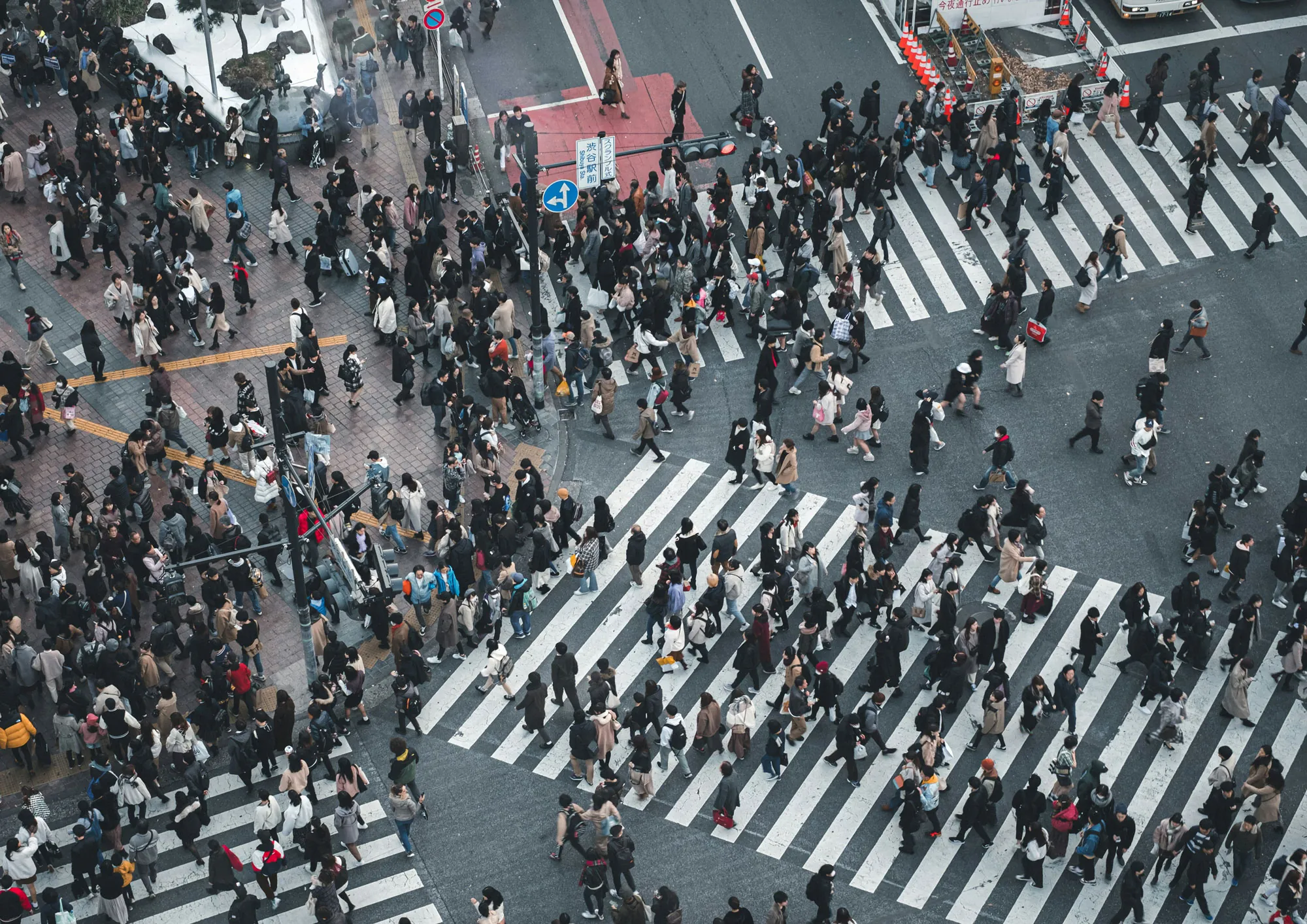 People crossing a very busy street during daytime
